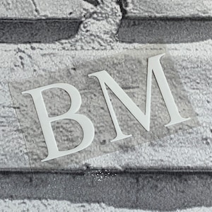 May include: White vinyl sticker with the letters "BM" in a serif font.