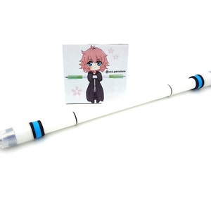 May include: White pen with blue and black accents. The pen has a clear tip and a clear end cap. A small sticker with a cartoon character is attached to the pen.
