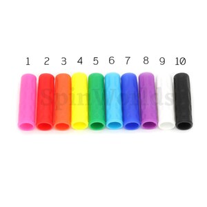 May include: Ten colorful silicone grips with a textured surface. The grips are numbered 1 through 10 and are in the following colors: pink, red, orange, yellow, green, blue, light blue, purple, white, and black.