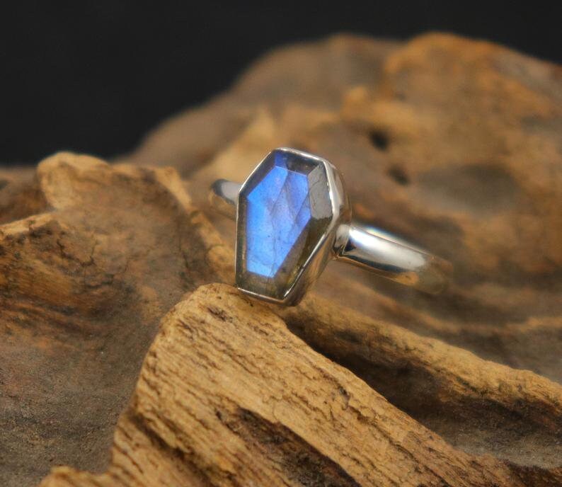 K&ouml;nnte beinhalten: Ein silberner Ring mit einem blauen Labradorit-Edelstein in Sargform.