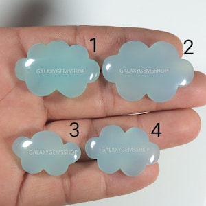 May include: Four light blue cloud-shaped cabochons, each with the text "GALAXYGEMSSHOP" on the surface. The cabochons are numbered 1 through 4.