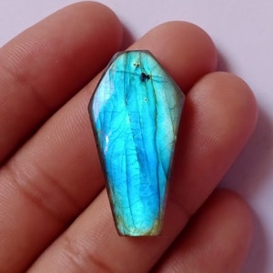 Può includere: Una pietra preziosa di labradorite blu sfaccettata a forma di lacrima con un bagliore iridescente.