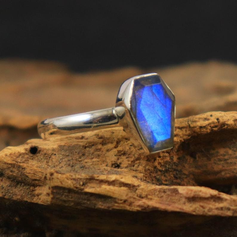 K&ouml;nnte beinhalten: Ein silberner Ring mit einem blauen Labradorit-Edelstein, der in einer Sargformfassung gefasst ist.