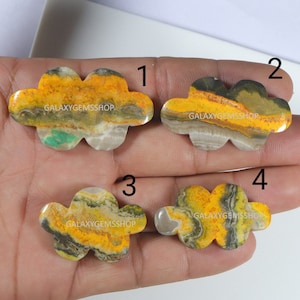 May include: Four yellow, brown, and gray cloudy shaped stones with a white background. The stones are labeled 1, 2, 3, and 4. The text "GALAXYGEMSSHOP" is printed on each stone.