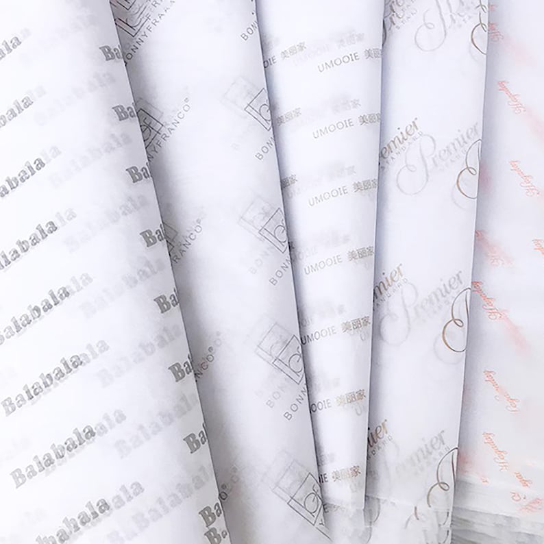 Może przedstawiać: Zbliżenie na kilka białych arkuszy papieru tiulowgo z nadrukowanymi r&oacute;żnymi logotypami firm. Logotypy obejmują "Balabala", "Bonnyfranco", "Umooie" i "Premier".