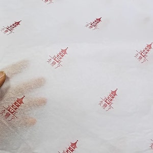 Może przedstawiać: Biały papier jedwabny z powtarzającym się wzorem czerwonej pagody z chińskimi znakami, kt&oacute;re brzmią "Nie drogi".