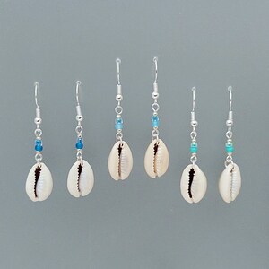 May include: Five pairs of silver earrings with cowrie shells and blue and turquoise beads.