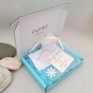 May include: A turquoise blue box with a white label that says "Craft Hut Cornwall" and a white tag that says "Your Jewellery Here". The box is filled with blue tissue paper and a white organza bag.