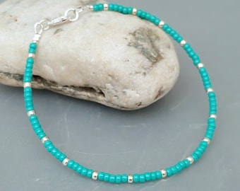 May include: A turquoise and silver beaded bracelet with a silver clasp.