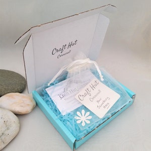 May include: A turquoise blue box with a white label that says "Craft Hut Cornwall" and a white tag that says "Your Jewellery Here". The box is filled with blue tissue paper and a white organza bag.