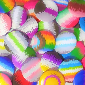 Könnte beinhalten: Eine Sammlung runder, bunter Knöpfe mit abstrakten Mustern. Die Knöpfe sind aus Metall und haben eine glänzende Oberfläche. Die Muster bestehen aus Streifen und Wirbeln in verschiedenen Farben, darunter Rot, Blau, Grün, Gelb, Lila und Weiß.