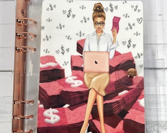 Peut inclure: Un classeur en plastique transparent avec un motif coloré représentant une femme assise sur une pile d'argent. Le motif comprend des signes de dollars, des cœurs et un ordinateur portable.