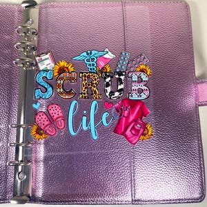May include: A purple binder with silver rings and the words "SCRUB LIFE" in colorful letters. The binder has decorative images of medical symbols, sunflowers, pink clogs, and a pink scrub top.