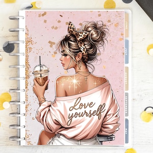 Può includere: Una copertina di agenda con l'illustrazione di una donna con una fascia leopardata, che tiene in mano un caffè. Indossa un top rosa con spalle scoperte con la scritta "Love yourself" in oro. Lo sfondo è rosa con glitter dorati.
