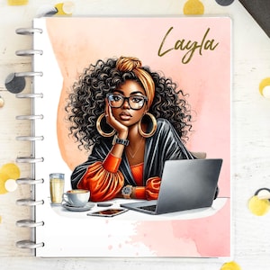 Può includere: Un'agenda a spirale con un'illustrazione di una donna con occhiali, foulard e grandi orecchini a cerchio. La copertina dell'agenda riporta il nome "Layla" in oro. Sono visibili anche un laptop, un caffè e uno smartphone.