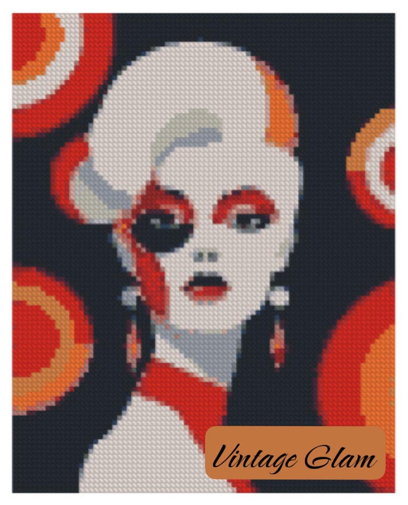 May include: A cross-stitch portrait of a woman in a retro style. The artwork features a white face with red lips and eye makeup, a black eye patch, and red accents. The background is dark with orange and red circular designs. The text "Vintage Glam" is at the bottom.