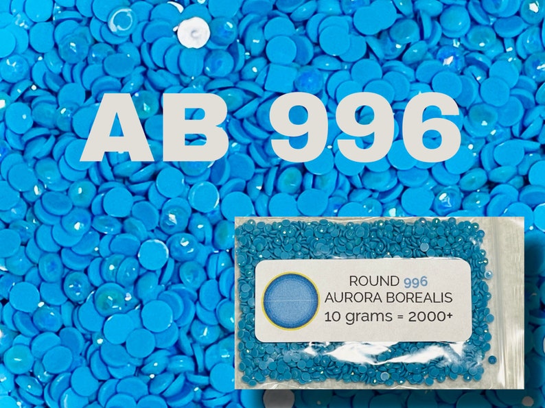 May include: A close-up image of a bag of small, round, turquoise blue rhinestones. The bag is labeled "ROUND 996 AURORA BOREALIS 10 grams = 2000+".