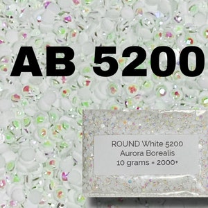 May include: A close-up of a bag of white round iridescent glitter, labeled "ROUND White 5200 Aurora Borealis 10 grams = 2000+"