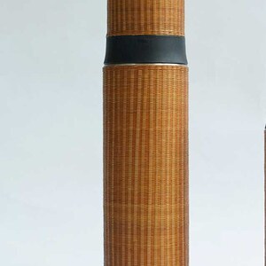 Puede incluir: Una botella de agua aislada de bamb&uacute; marr&oacute;n con una tapa negra y una banda plateada. La botella tiene el texto "Nature Bamboo 自然家" impreso en ella.