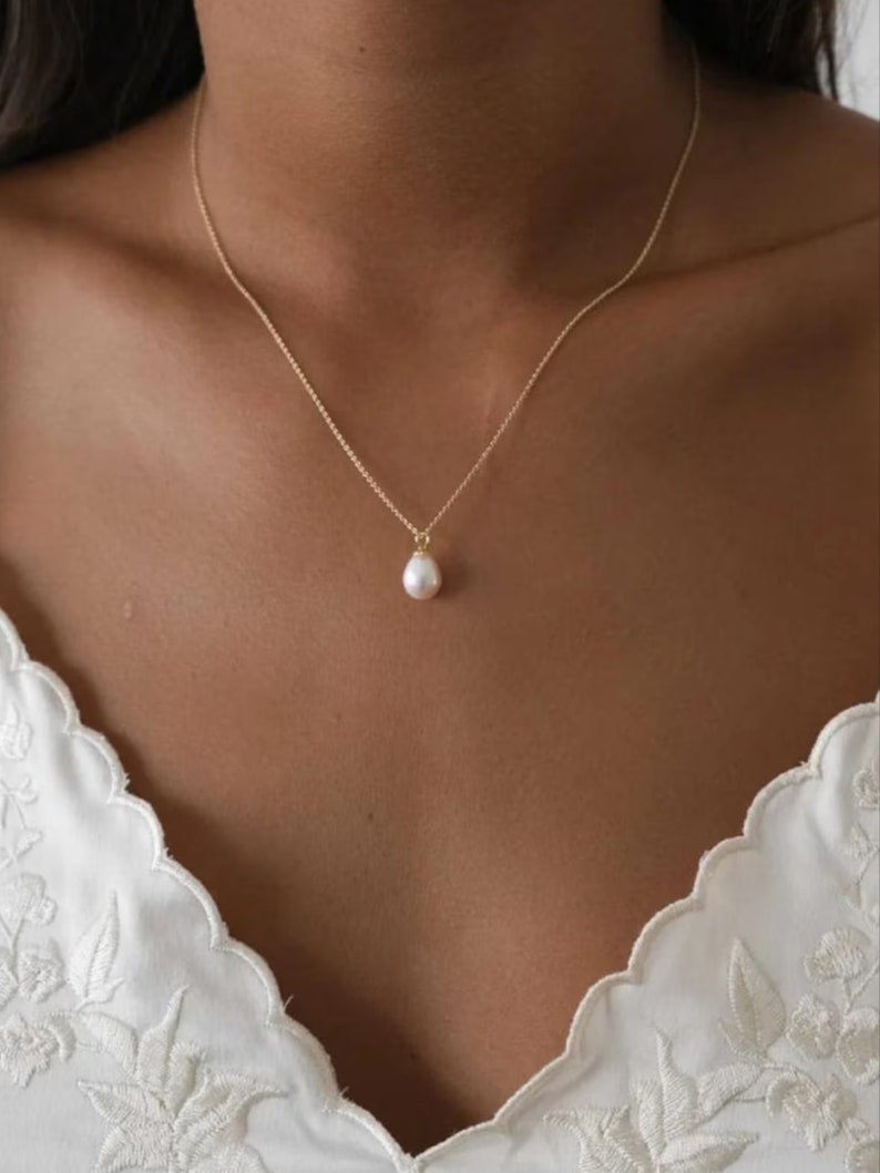 Alt text describes the delicate design of this necklace featuring natural pearls, plated in gold for an elegant touch. Its minimalist style adds sophistication to any outfit, making it a versatile addition to your jewelry collection.