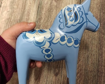 Könnte beinhalten: Ein blaues Holzpferd mit weißen und blauen bemalten Mustern. Das Pferd ist ein traditionelles schwedisches Dala-Pferd.