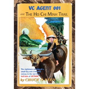 May include: A vintage book cover with the title "VC AGENT 001 and The Ho Chi Minh Trail." The cover art depicts a young person riding a water buffalo, with a war scene in the background. The book is by Chuck O. Keen.