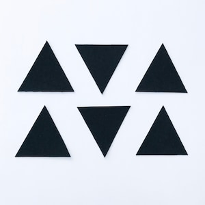 Peut inclure: Six triangles en papier noir disposés de manière symétrique sur un fond blanc.