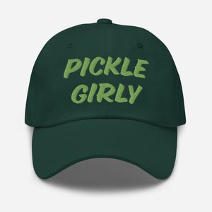 Op de afbeelding: Een donkergroene baseballpet met de tekst "PICKLE GIRLY" geborduurd in lichtgroen.