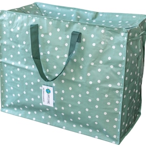 May include: A large rectangular storage bag in sage green with a white polka dot pattern. It features two dark green woven handles and a white rectangular tag attached to one handle that reads HAPPY PLANET and MADE USING RECYCLED MATERIALS.