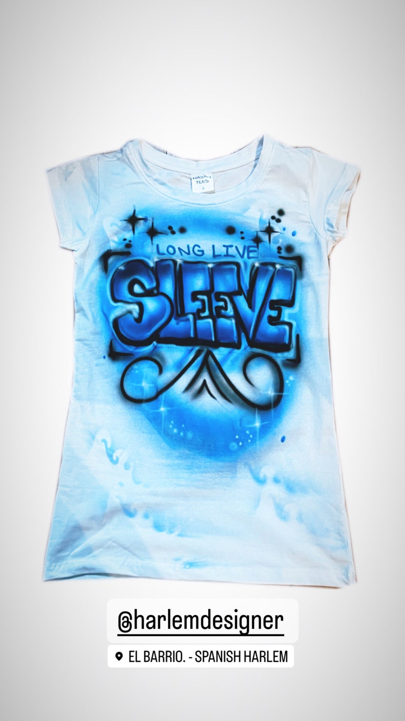 May include: Light blue t-shirt with a blue and black graffiti design that says "Long Live Sleeve".