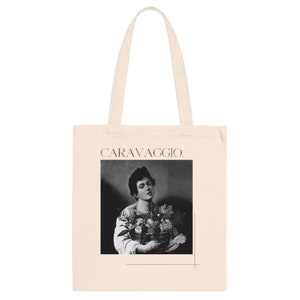 May include: A tote bag with a black and white image of a man holding a basket of fruit. The text "CARAVAGGIO." is printed on the bag.