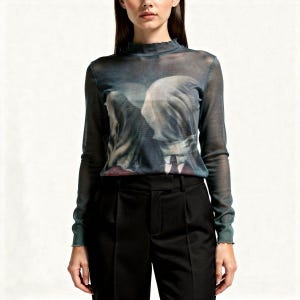 Op de afbeelding: Een doorschijnende top met lange mouwen, een hoge halslijn en een unieke print. De print heeft een surrealistisch, artistiek ontwerp in tinten blauw, grijs en wit. De top wordt gecombineerd met een zwarte broek. De top heeft een geschulpte rand bij de halslijn en manchetten.