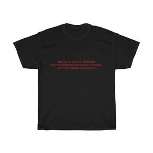 May include: Black t-shirt with the red text: "THE AIM OF ART IS TO REPRESENT NOT THE OUTWARD APPEARANCE OF THINGS, BUT THEIR INWARD SIGNIFICANCE." The shirt is a classic crew neck style, made of a soft material.
