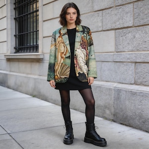 May include: A woman wearing a black dress, black tights, and black combat boots. The focal point is a blazer with a Renaissance art print in shades of green, beige, and brown. The blazer features a classic lapel and button closure.