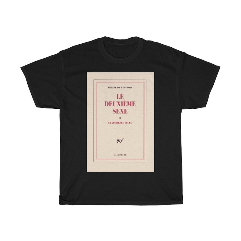 Op de afbeelding: Zwart T-shirt met de boekomslag van "Le Deuxi&egrave;me Sexe" van Simone de Beauvoir. Het ontwerp toont de titel in het rood, de naam van de auteur en het logo van de uitgever.
