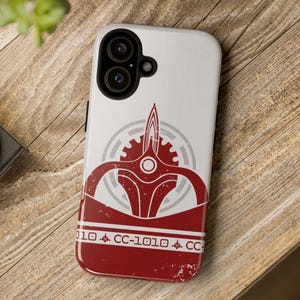 May include: A white phone case with a red and white design. The design features a stylized spaceship with the text "CC-1010" on the bottom.