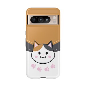 May include: A white phone case with a cartoon calico cat peeking out of a pocket. The cat has black and gray ears, orange and white fur, and pink paw prints are on the bottom of the case.