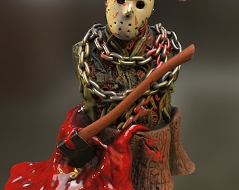 May include: A bust of Jason Voorhees from the Friday the 13th franchise. The bust is made of a dark green material and is covered in chains. Jason is wearing his iconic hockey mask and is holding a bloody axe. The bust is sitting on a tree stump with red blood dripping down the sides.