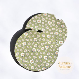 May include: Two green round coasters with a white daisy pattern. The coasters are stacked on top of each other. The text "Lexus Nalene" is visible in the bottom right corner of the image.