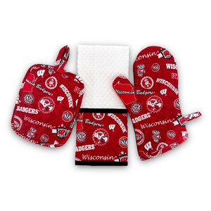 May include: A red and white kitchen towel set featuring the Wisconsin Badgers logo. The set includes a potholder, oven mitt, and a tea towel.