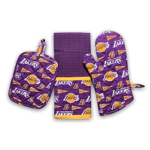 May include: A purple and gold kitchen towel set with a Los Angeles Lakers theme. The set includes a potholder, oven mitt, and a dish towel. The set features a repeating pattern of the Lakers logo and the words "Los Angeles Lakers".