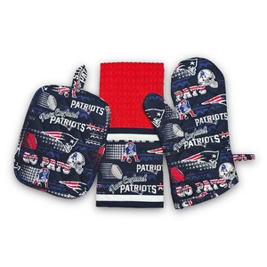 May include: A set of three kitchen accessories featuring the New England Patriots logo. The set includes a red dish towel, a blue oven mitt, and a blue pot holder. All three items feature the Patriots logo and the words "Go Pats" and "New England Patriots".
