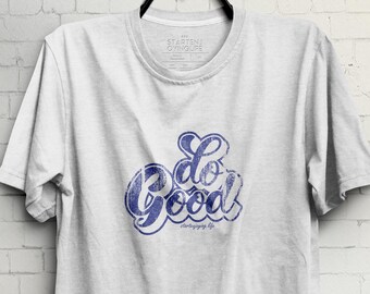 May include: White t-shirt with a blue and white graphic that says "Do Good".