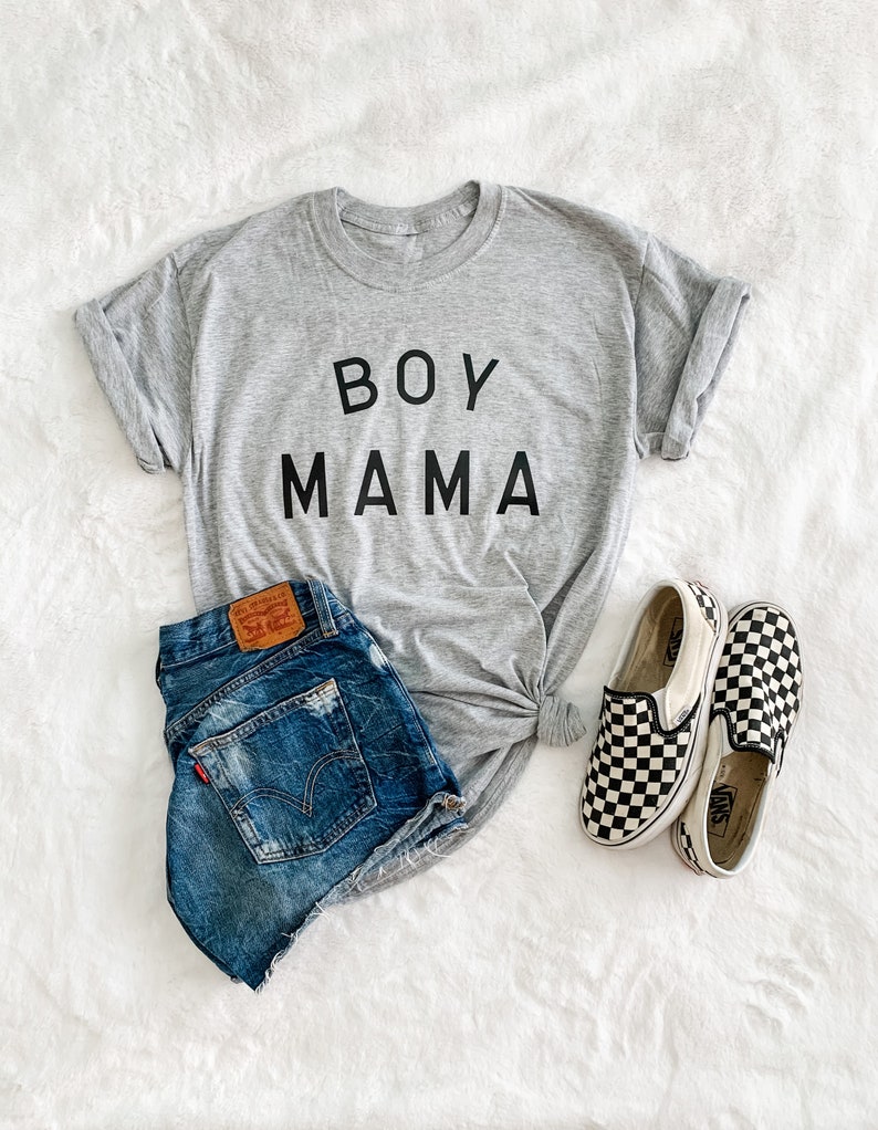 Peut inclure: Un t-shirt gris avec l'inscription "BOY MAMA" en noir, associ&eacute; &agrave; un short en jean et des chaussures &agrave; enfiler &agrave; carreaux noirs et blancs. Le short a une &eacute;tiquette Levi's.