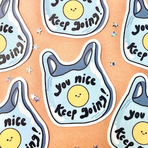 May include: A collection of stickers featuring a cartoon plastic bag design. The bag is light blue with a yellow smiling face and the words "you nice keep going!" in black. Scattered around are star-shaped confetti.