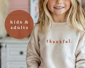 May include: A beige crewneck sweatshirt featuring the word thankful. printed in rust-colored lowercase letters on the chest. The image includes the text THE SIBLING EDIT at the top and a rust-colored circle containing the text kids & adults.