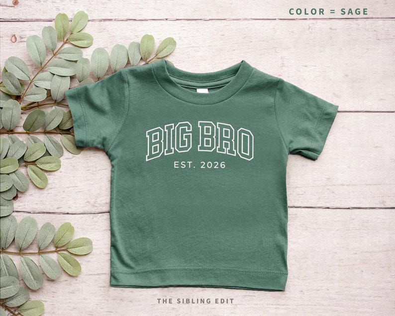 Puede incluir: Camiseta verde salvia para ni&ntilde;os peque&ntilde;os con el texto "BIG BRO EST. 2026" en blanco, con letras de estilo universitario. La camiseta tiene mangas cortas y cuello redondo. Las palabras "COLOR = SAGE" est&aacute;n en la parte superior y "THE SIBLING EDIT" en la parte inferior.