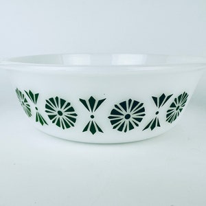 Peut inclure: Bol en verre blanc avec un motif floral vert foncé sur l'extérieur. Le bol a une forme arrondie avec un bord légèrement évasé. Le motif floral est un motif répétitif de fleurs stylisées et de formes géométriques.