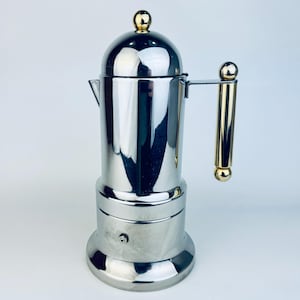 May include: A set of three ceramic mugs with a speckled, matte finish. The mugs are in shades of cream, light gray, and dark gray. Each mug has a simple, minimalist design, perfect for coffee or tea.