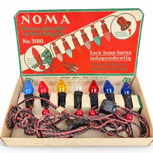 以下が含まれることがあります： オリジナルの赤と白の段ボール箱に入ったヴィンテージのNOMA No. 3010装飾照明セット。このセットには、青、赤、黄、透明の7つのマルチカラー電球が含まれており、黒と赤のツイストワイヤーで接続されています。